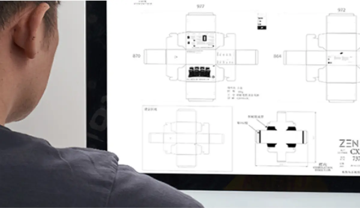 Designer scrutinizing package design blueprints on a computer screen