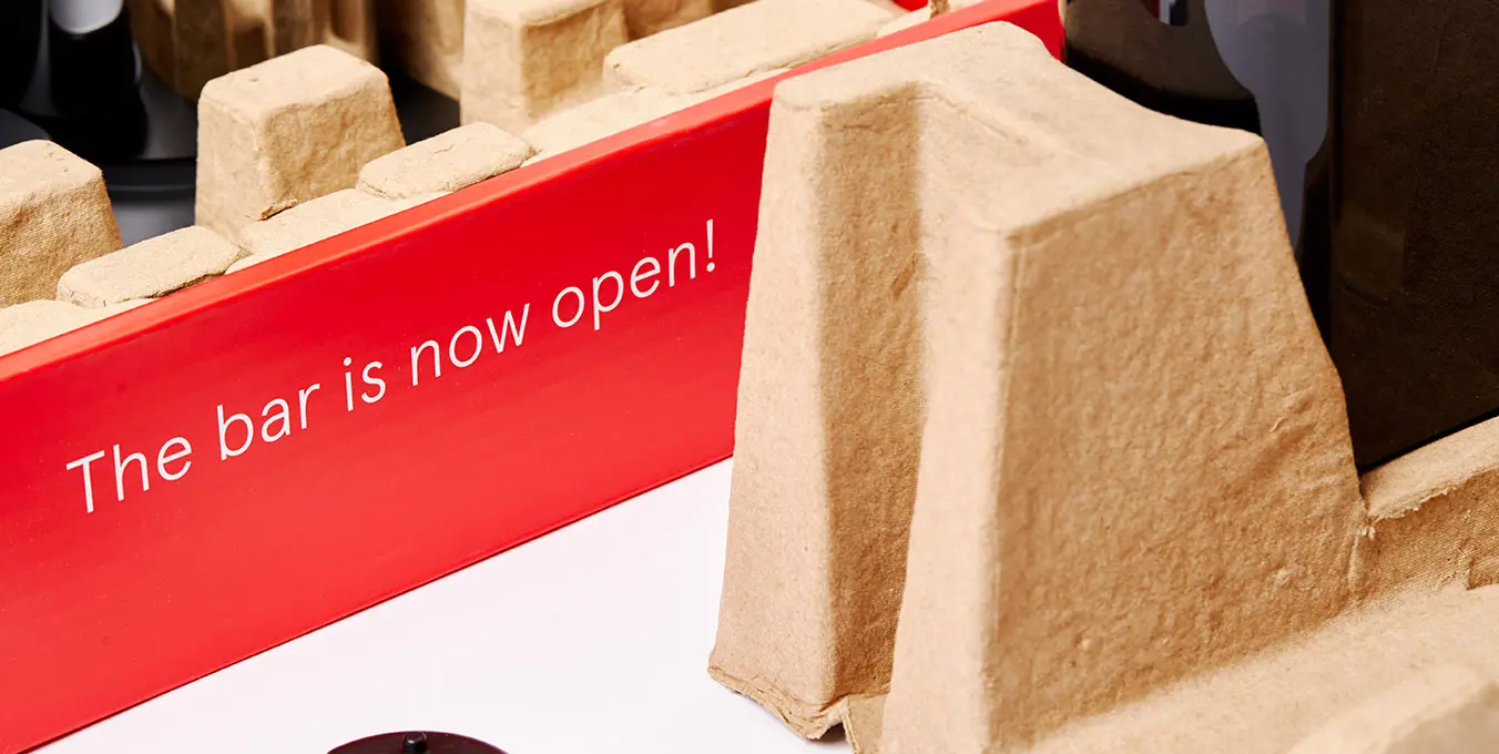 Drinkworks bar's inventive packaging with easy-open feature and bold 'The bar is now open!' signage.