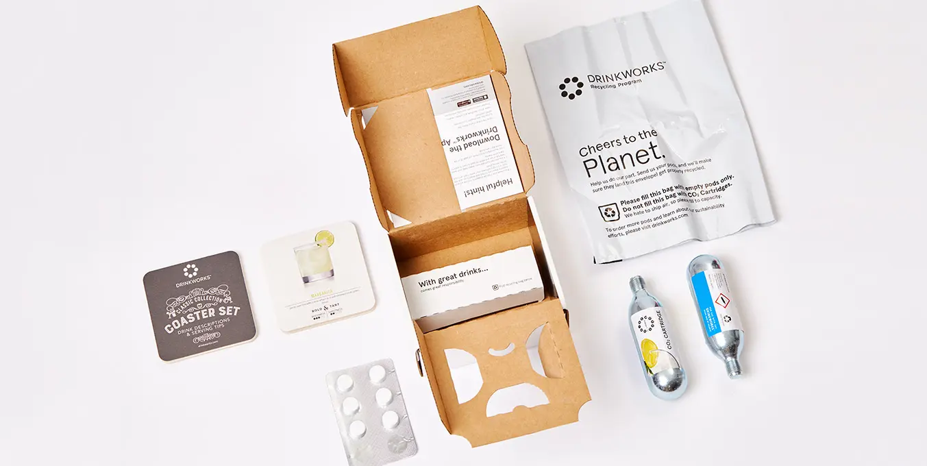 Inside view of Drinkworks packaging, featuring eco-friendly molded pulp tray and secure, easy-open locks.