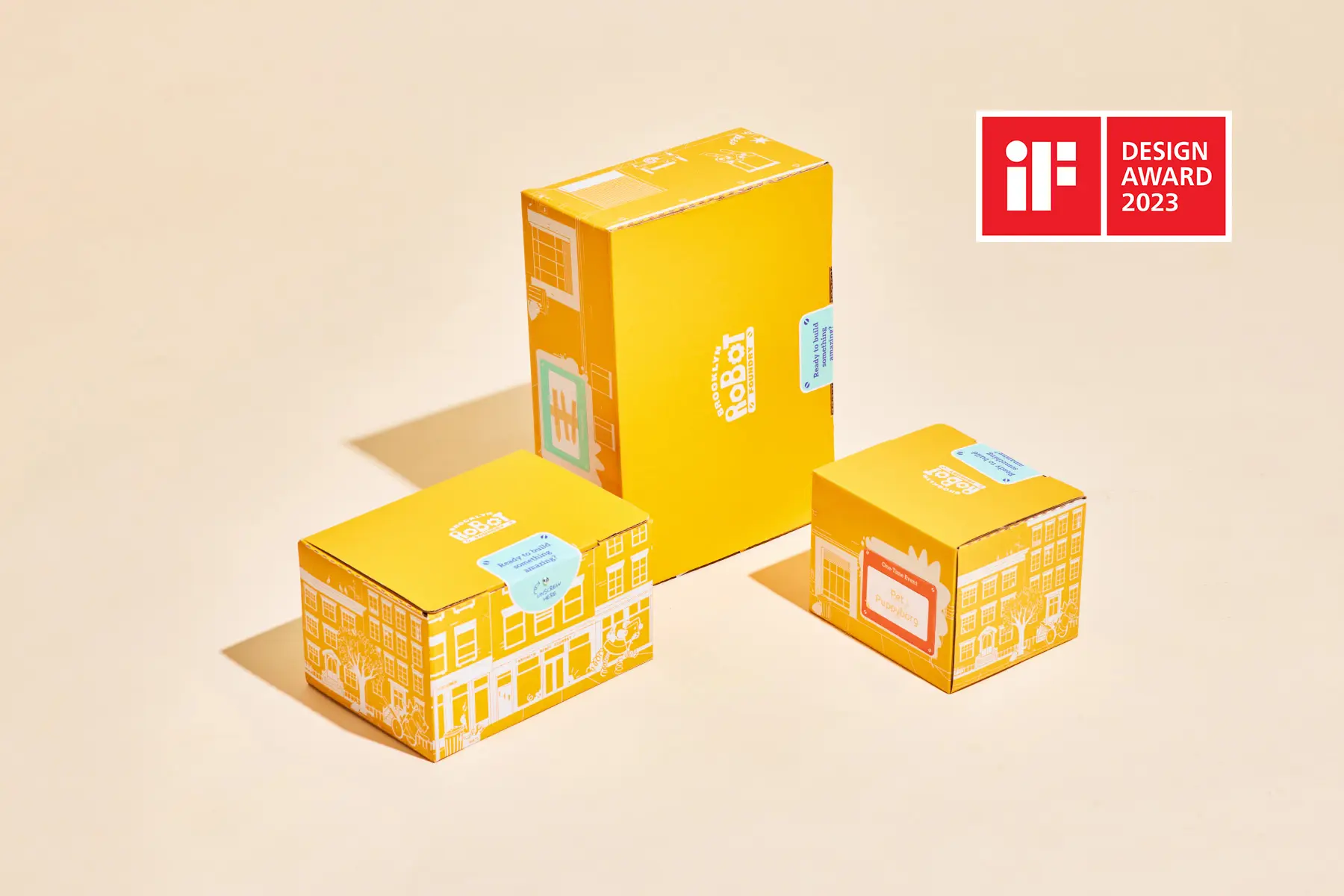 Bright orange educational toy packaging with custom robot designs for Brooklyn Robot Foundry.