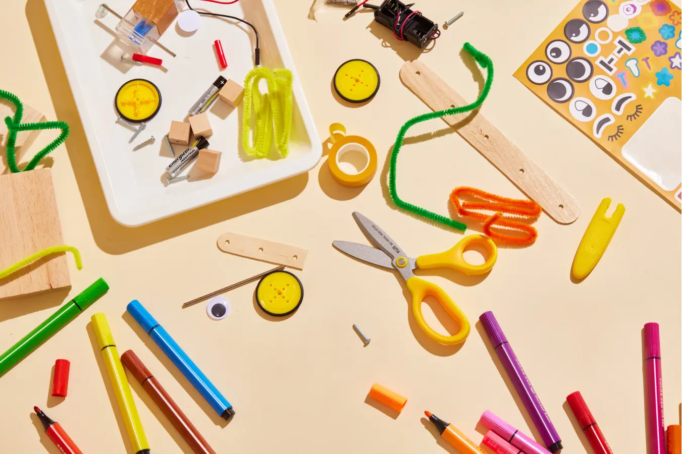 Colorful assortment of educational toy parts for robot building on a sunny background.