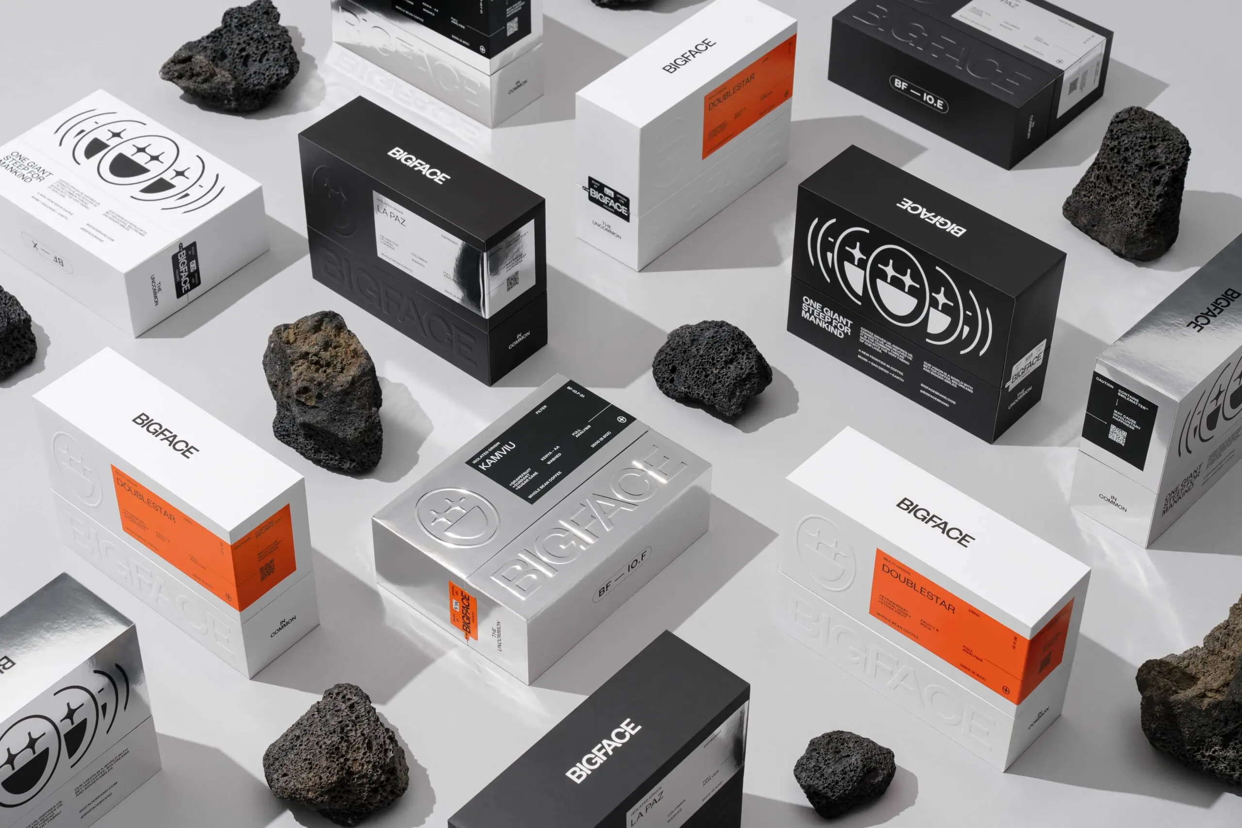Premium custom packaging for coffee featuring embossed logo design in silver, black, and white finishes.