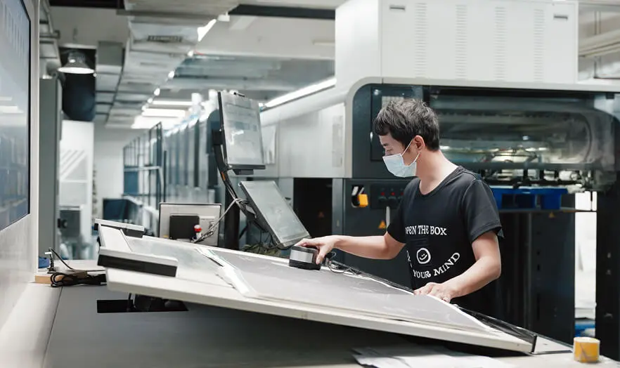 Quality control technician conducting in-process print inspection for Zenpack packaging quality assurance.