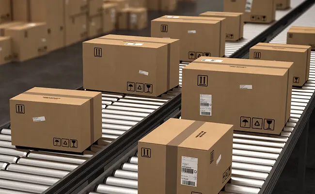 Cardboard boxes moving on a manufacturing conveyor belt for automated packaging efficiency and supply chain logistics.