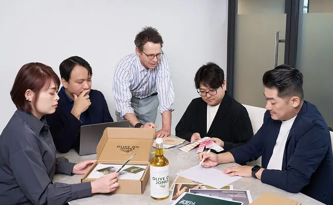 Zenpack packaging consulting team meeting around a table to discuss strategy, structural design, and material samples.