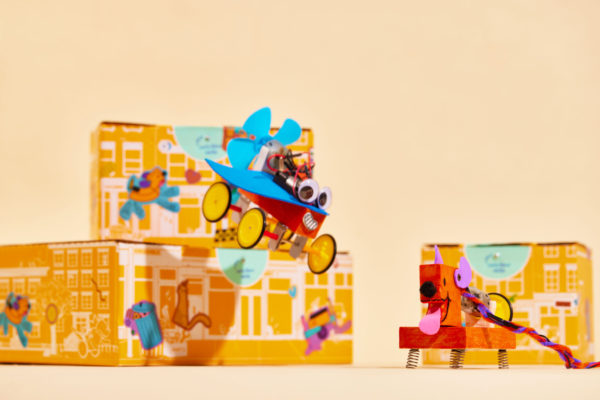 Cheerful plush robot toy in front of Brooklyn Robot Foundry packaging with vibrant Zenpack design.